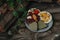 Chocolates with dried fruits on a plate on a wooden table