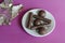 Chocolates, white saucer and candy wrapper on pink background