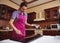 Chocolatier holding cake scrapers near melted chocolate on marble surface on the background of wooden kitchen