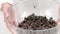 Chocolatier shaking chocolate couverture callets in glass bowl close up slow mo