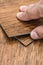 Choice of flooring. Renovation or construction concept. Close-up of a male hand holding a textured vinyl floor tile