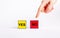 Choice between positive and negative decisions concept. Forefinger pointing to red cube with no text instead of yellow