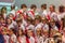 Choir of pupils standing on the stage. Festive students holding flowers.