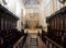 Choir stalls in church interior with rows of pews and steps leading up to the altar