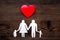 Choose family health insurance. Paper heart and silhouette of family on dark wooden background top view copyspace