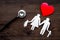 Choose family health insurance. Stethoscope, paper heart and silhouette of family on dark wooden background top view