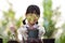 Choose focus on the potted plants. Kid little gardener`s hand holding a plant pot stood in front of him. cute face girl She was le