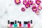 Choose nail polish for manicure. Bottles of colored polish on grey background top view copyspace