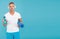 Choose sport drink wisely. Athletic man hold sport bottle and gym mat. Handsome sportsman blue background. Hydration for