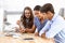 Choosing the correct image to promote their brand. Three young editors looking at photos in their office.