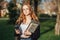 Choosing a university, college. Female college student with books and laptop outdoors. Redhead college student girl with