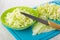 Chopped cabbage on cutting board, bowl with chopped cabbage, knife on wooden table