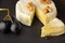 Chopped camembert on a dark background with nuts, grapes and honey