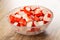 Chopped crab sticks in transparent bowl on wooden table