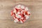 Chopped crab sticks in transparent bowl on wooden table