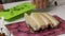 The chopped fat lies on the board. A woman is chopping parsley. Salted lard with herbs and spices