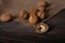 Chopped half of a walnut lies on a wooden table in the foreground.