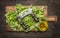 Chopped lettuce with knife for herbs on a cutting board with oil wooden rustic background top view close up