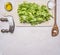 Chopped lettuce with knife for herbs, on a white cutting board with oil with a wooden spoon salad heart wooden rustic