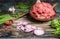 Chopped meat in pan with wooden spoon and ingredients for tasty cooking