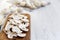 Chopped mushrooms on wooden chopping board over white wooden background, close-up. Side view.