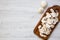 Chopped mushrooms on wooden chopping board, overhead. White wooden background. Flat lay, top view.