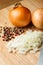 Chopped Onion on Wooden Cutting Board with Knife and Pepper