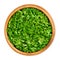 Chopped parsley, fresh cut, flat leaved parsley, in a wooden bowl