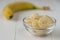 Chopped pieces of banana in a glass bowl on a wooden table.