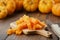 Chopped pumpkin pulp on cutting board. Several pumpkins in background