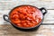 Chopped tinned red tomatoes in a pan. White background. Top view