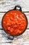 Chopped tinned red tomatoes in a pan. White background. Top view