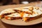 Chopped triangles of quesadillas with vegetables and herbs and sauce on wooden board