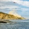 Chopper in flight over cliff and ocean in La Jolla