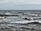 Choppy atlantic ocean waves with surf and grey winter clouds