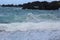 Choppy waters of the Pacific Ocean along a jagged, volcanic rocky shoreline in Hana, Maui, Hawaii