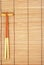 Chopsticks on brown bamboo matting background
