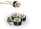 Chopsticks pick sushi up from a plate.