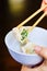 Chopsticks Pick Up an Opened Chinese Dumpling from a Bowl