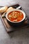 Chorba Hamra bel Frik Algerian Lamb, Tomato, and Freekeh Soup close-up in a plate. Vertical