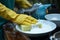 Daily chore closeup Gloved hand wields a sponge, post meal cleanup in the kitchen