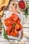 Chorizo sausage thin cut on a cutting board. Spanish salami with spices, paprika, pepper. Spicy food. White background. Top view