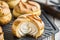 Choux au Craquelin: A display of choux pastry puffs, sugar-coated shells encasing cream filling