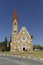 The Christ Church, Christuskirche is a historic landmark and Lutheran church in Windhoek, Namibia. Blue sky, palm trees