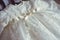 Christening baby dress. Close-up of a cute newborn baby dress. Stylish embroidered white dress. Concept childhood education and fa