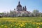 Christian baroque monastery in blooming spring meadow.