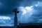 Christian cross against dramatic gloomy dark sky, with sunbeams coming through gloomy clouds of great flood, concept of last