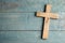 Christian cross on blue wooden background, top view with space for text. Religion concept