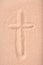 Christian cross drawn in dry sand