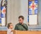 Christian dad tells his son Bible stories about Jesus sitting in kirk. Faith, religious education, modern church, father